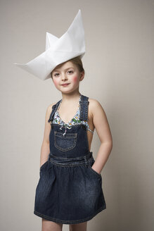 Porträt eines modischen kleinen Mädchens mit großem Papierboot auf dem Kopf - FSF01008