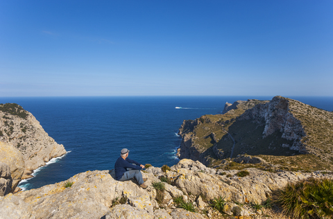 Spanien, Balearen, Mallorca, Cap de Formentor, Wanderer schaut in die Ferne, lizenzfreies Stockfoto