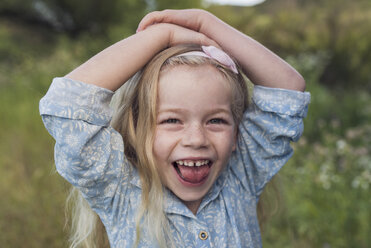 Porträt eines glücklichen Mädchens mit Händen auf dem Kopf im Park stehend - CAVF26947