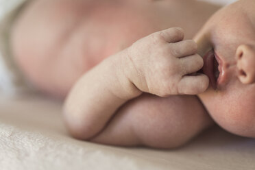 Abgeschnittenes Bild von hemdsärmeligen Baby Mädchen auf dem Bett liegend - CAVF26985