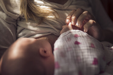 Mittelteil einer Mutter, die ihre neugeborene Tochter zu Hause stillt - CAVF26994