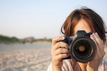 Close-up of woman holding camera - CAVF27057