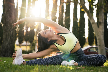 Frau dehnt sich beim Yoga im Park - CAVF27129