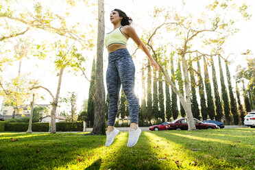 Frau springt beim Sport im Park - CAVF27133
