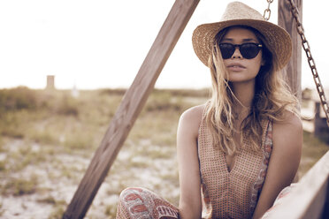 Nahaufnahme einer Frau mit Sonnenbrille auf einem Feld an einem sonnigen Tag - CAVF27148