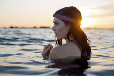 Nahaufnahme einer Frau im Wasser am Strand bei Sonnenuntergang - CAVF27155