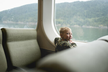 Porträt eines am Fenster sitzenden Jungen während einer Zugfahrt - CAVF27161