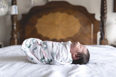 Side view of newborn baby girl wrapped in blanket - CAVF27169