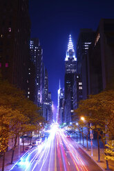 Light trails on road by illuminated buildings at night - CAVF27224