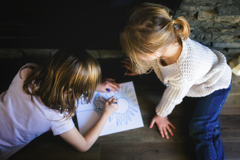 Draufsicht auf ein Mädchen, das seine Schwester beim Zeichnen auf dem Papier betrachtet - CAVF27246