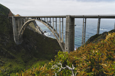 Arch bridge over mountains by sea - CAVF27276