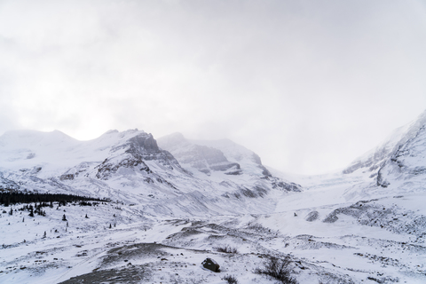 Niedriger Winkel Blick auf schneebedeckten Berg gegen Himmel bei nebligem Wetter, lizenzfreies Stockfoto