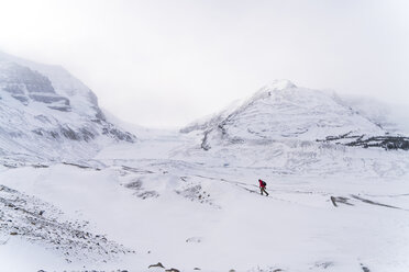 Blick aus der mittleren Entfernung auf einen Wanderer in einer verschneiten Landschaft bei nebligem Wetter - CAVF27330