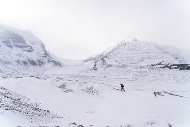 Mid distance view of hiker walking on snow covered landscape during foggy weather - CAVF27330