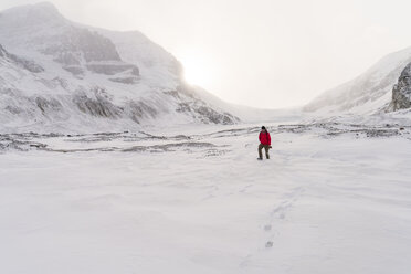 Hiker walking on snow covered landscape during foggy weather - CAVF27335