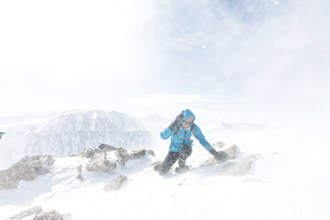 Frau auf schneebedecktem Berg bei Schneesturm - CAVF27395