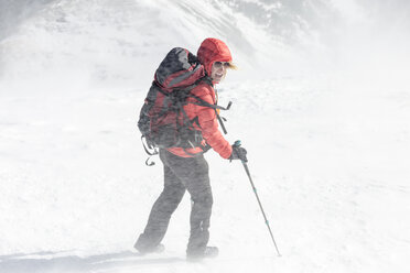 Hohe Winkel Ansicht der weiblichen Wanderer mit Rucksack hält Wanderstöcke während Schneesturm - CAVF27398