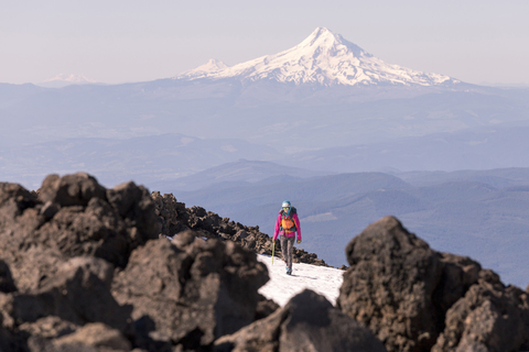 Woman hiking against snowcapped mountain during winter stock photo