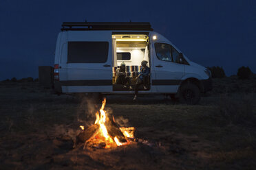 Freundinnen sitzen nachts im Wohnwagen auf dem Campingplatz - CAVF27409