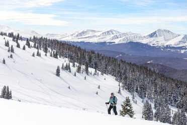 Frau beim Skifahren vor schneebedeckten Bergen - CAVF27417