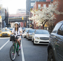 Happy couple riding bicycles on street - CAVF27453