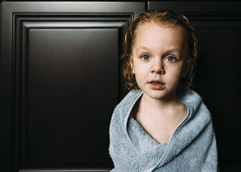 Portrait of boy wrapped in towel at home - CAVF27504