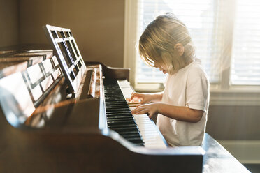 Boy practicing piano at home - CAVF27515