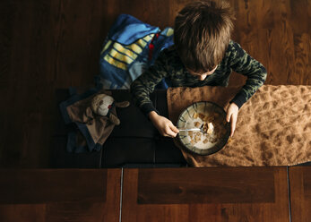 Draufsicht auf einen Jungen, der zu Hause Cornflakes isst - CAVF27520