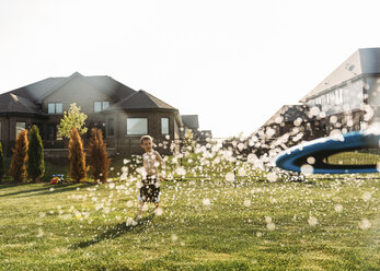 Shirtless boy playing at backyard on sunny day - CAVF27524