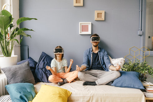 Vater und Sohn mit VR-Brille üben Yoga zu Hause - KNSF03610