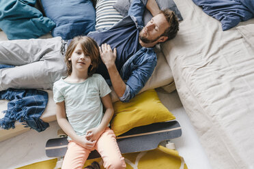 Father and son with skateboard relaxing at home - KNSF03615