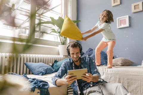 Father and son having a pillow fight at home stock photo