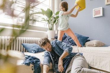 Father and son having a pillow fight at home - KNSF03617