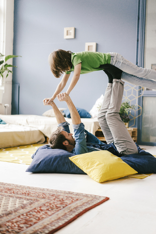 Glücklicher Vater und Sohn spielen zu Hause, lizenzfreies Stockfoto