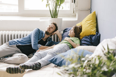 Lächelnder Vater und Sohn zu Hause mit Blick nach oben - KNSF03627