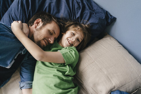 Father and son cuddling at home - KNSF03630