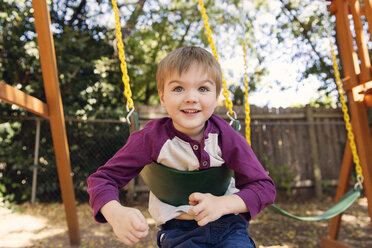 Porträt eines Jungen, der auf einer Schaukel im Park spielt - CAVF27565