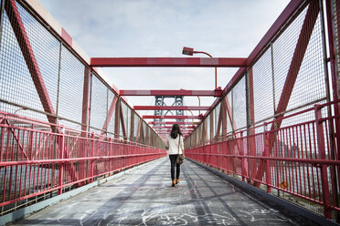 Rückansicht einer jungen Frau, die über die Williamsburg Bridge läuft - CAVF27577