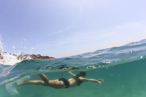 Woman swimming in sea against sky stock photo