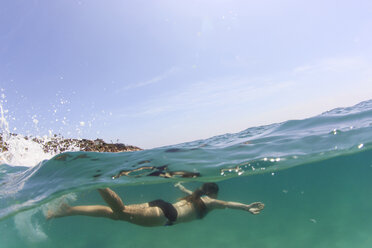 Frau schwimmt im Meer gegen den Himmel - CAVF27639