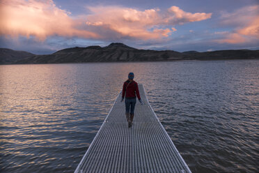 Rückansicht einer Frau, die auf einem Steg im Blue Mesa Reservoir spazieren geht - CAVF27647