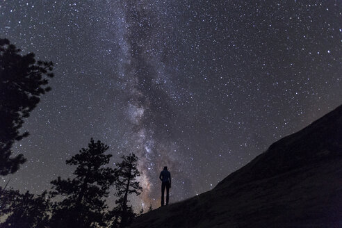 Silhouette einer Frau, die vor einem nächtlichen Sternenfeld steht - CAVF27673