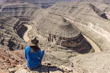 Rear view of woman sitting on mountain - CAVF27688