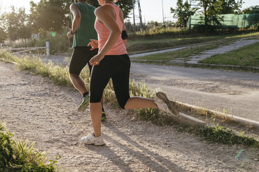 Tiefschnitt eines jungen Paares beim Joggen im Park - CAVF27752