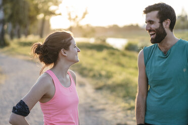 Happy couple standing face to face while exercising at park - CAVF27757