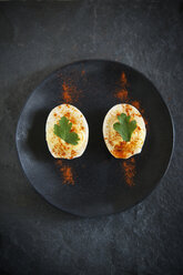 Overhead view of seasoned boiled egg slices served in plate - CAVF27830