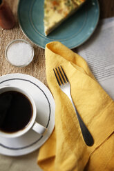 Overhead view of coffee cup with napkin on table - CAVF27834