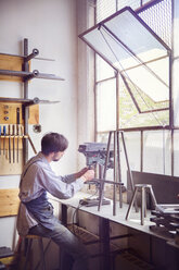 Male craftsperson working on machinery at wood shop - CAVF27845