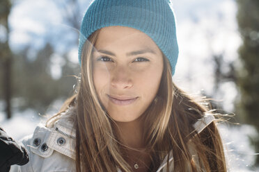 Porträt einer lächelnden Frau mit Strickmütze auf einem Feld im Winter - CAVF27913