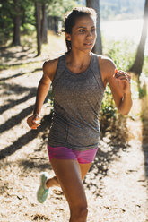 Woman jogging at field on sunny day - CAVF27947